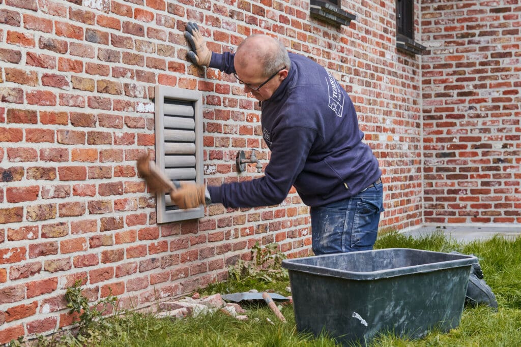 Groot hondenluik in stenen muur plaatsen door installateur van Tomsgates